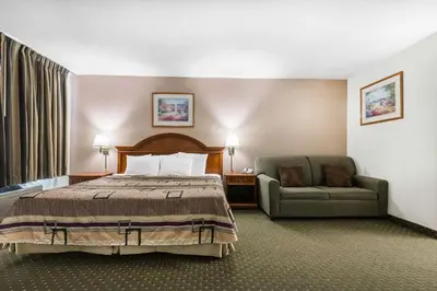 a hotel room with a bed and a couch at Quality Inn & Suites Binghamton Vestal in Binghamton