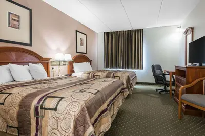 a hotel room with two beds and a desk at Quality Inn & Suites Binghamton Vestal in Binghamton