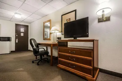 a hotel room with a desk with a tv and a chair at Quality Inn & Suites Binghamton Vestal in Binghamton