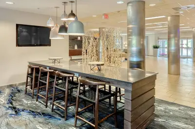 a lobby with a large table and stools at Fairfield Inn & Suites by Marriott Harrisburg West/New Cumberland in New Cumberland