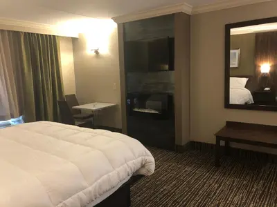 a hotel room with a bed and a mirror at The Lincoln Hotel Philadelphia in Trevose