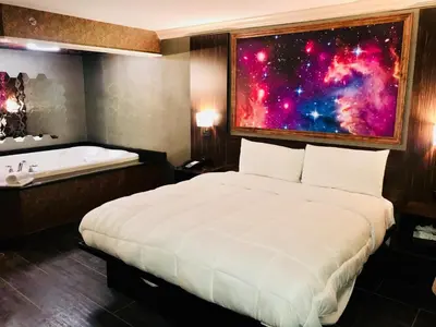 a bedroom with a bed and a bath tub at The Lincoln Hotel Philadelphia in Trevose