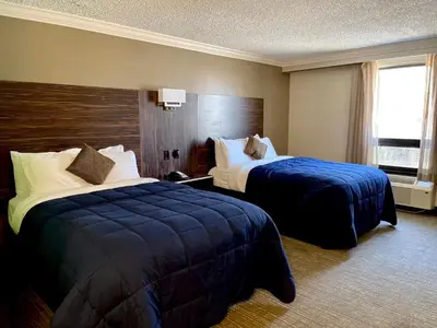 a hotel room with two beds and a window at The Lincoln Hotel Philadelphia in Trevose