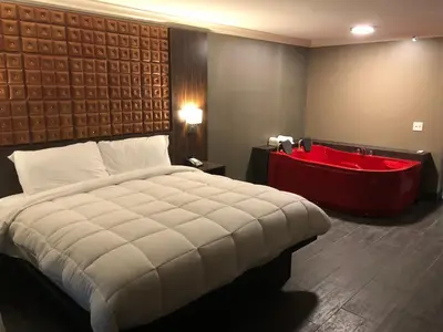 a bedroom with a large bed and a bath tub at The Lincoln Hotel Philadelphia in Trevose