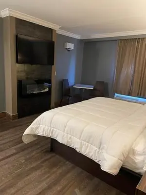 a bedroom with a bed and a flat screen tv at The Lincoln Hotel Philadelphia in Trevose