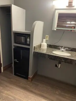 a bathroom with a sink and a microwave at The Lincoln Hotel Philadelphia in Trevose