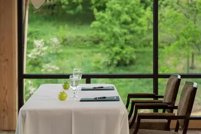 a table with two wine glasses and a window at Glasbern in Fogelsville