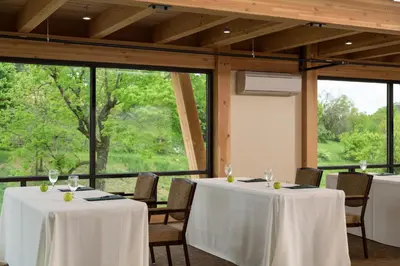 a room with two tables and chairs and windows at Glasbern in Fogelsville
