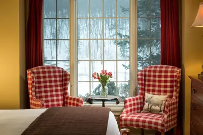 two chairs and a table in a room with a window at Glasbern in Fogelsville