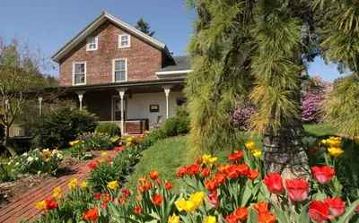 a house with a bunch of flowers in front of it at Glasbern in Fogelsville