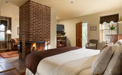 a bedroom with a bed and a brick fireplace at Glasbern in Fogelsville