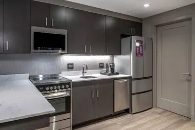 a kitchen with wooden cabinets and a stainless steel refrigerator at Residence Inn by Marriott Weehawken in Weehawken