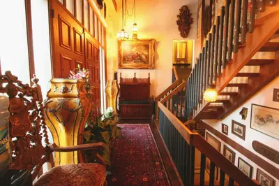 a hallway with stairs with a vase and a stair case at Alpenhof Bed & Breakfast in Media