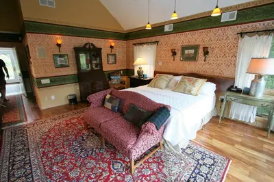 a bedroom with a large bed and a couch at Alpenhof Bed & Breakfast in Media
