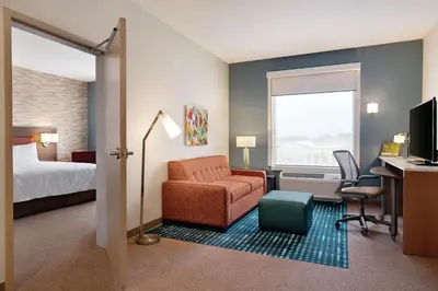a hotel room with a bed and a chair and a desk at Home2 Suites By Hilton Lancaster in Lancaster