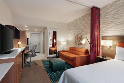 a hotel room with a bed and a living room at Home2 Suites By Hilton Lancaster in Lancaster