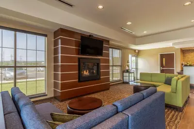 a living room with a couch and a fireplace at Comfort Inn & Suites - Harrisburg Airport - Hershey South in Middletown