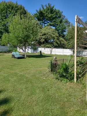a yard with a fence and a bench in the grass at Red brick house in Chalfont