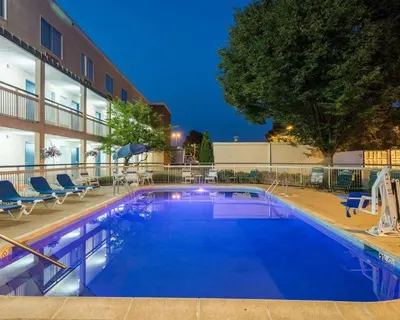 a large swimming pool with chairs and a building at Quality Inn Newark - Wilmington in Newark