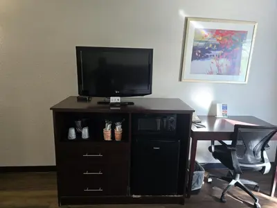 a television on top of a dresser with a desk at Quality Inn Newark - Wilmington in Newark