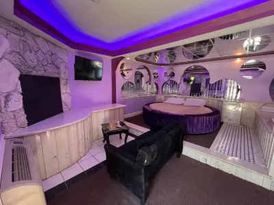 a purple room with a bed and a couch at Gallery Holiday Motel in South Amboy