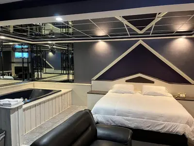 a bedroom with a large bed and a bath tub at Gallery Holiday Motel in South Amboy
