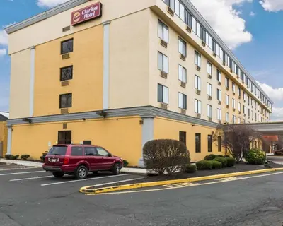 a red car parked in a parking lot in front of a hotel at Clarion Hotel Somerset - New Brunswick in Somerset