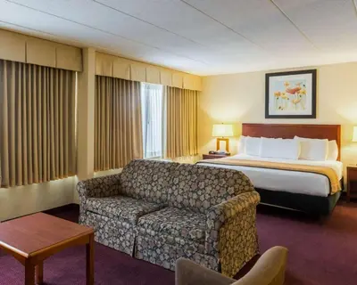 a hotel room with a bed and a couch at Clarion Hotel Somerset - New Brunswick in Somerset