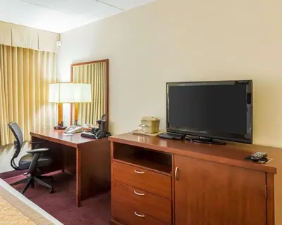 a hotel room with a desk and a television on a dresser at Clarion Hotel Somerset - New Brunswick in Somerset