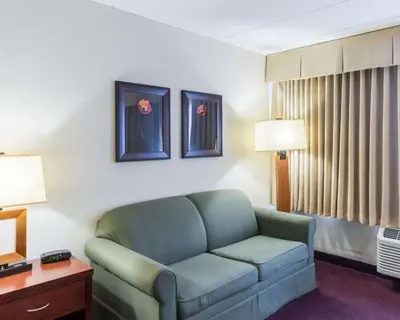 a living room with a couch in a hotel room at Clarion Hotel Somerset - New Brunswick in Somerset