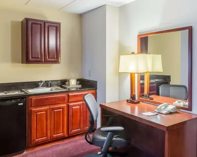 a room with a desk with a lamp and a sink at Clarion Hotel Somerset - New Brunswick in Somerset