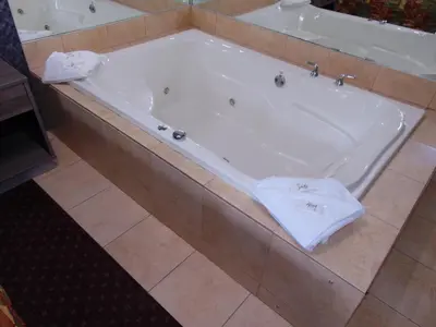 a bath tub with two towels in a bathroom at La Mirage Motor Inn in Monmouth Junction