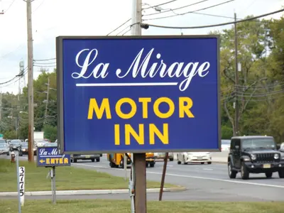 a blue sign that says la village motor inn at La Mirage Motor Inn in Monmouth Junction