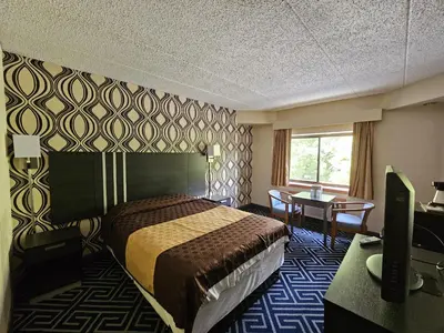 a hotel room with a bed and a desk at La Mirage Motor Inn in Monmouth Junction