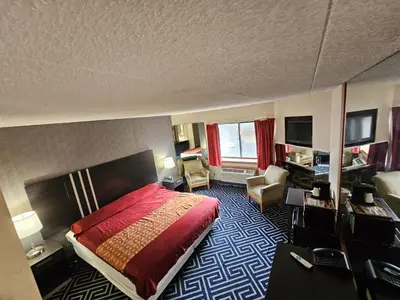 a hotel room with a bed and a chair at La Mirage Motor Inn in Monmouth Junction