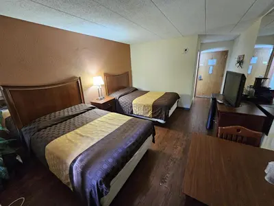 a hotel room with two beds and a flat screen tv at La Mirage Motor Inn in Monmouth Junction