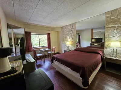 a hotel room with a large bed and a desk at La Mirage Motor Inn in Monmouth Junction