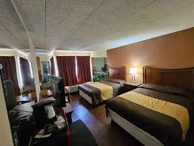 a hotel room with two beds and a television at La Mirage Motor Inn in Monmouth Junction