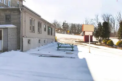 a picnic table in the snow next to a building at OYO Hotel Wilkes-Barre East in Wilkes-Barre