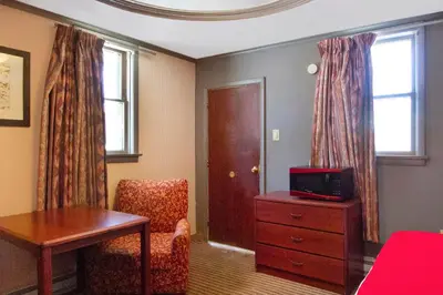 a room with a desk and a chair and a table at OYO Hotel Wilkes-Barre East in Wilkes-Barre