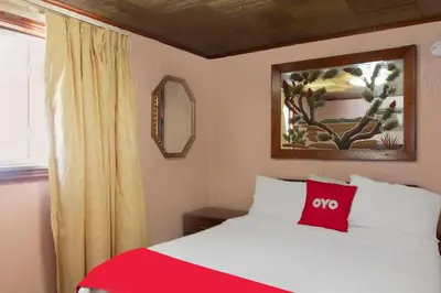 a bedroom with a bed with a red pillow on it at OYO Hotel Wilkes-Barre East in Wilkes-Barre