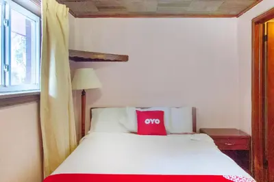 a bedroom with a white bed with a red pillow at OYO Hotel Wilkes-Barre East in Wilkes-Barre
