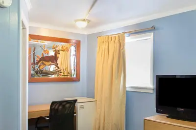 a living room with a television and a window at OYO Hotel Wilkes-Barre East in Wilkes-Barre