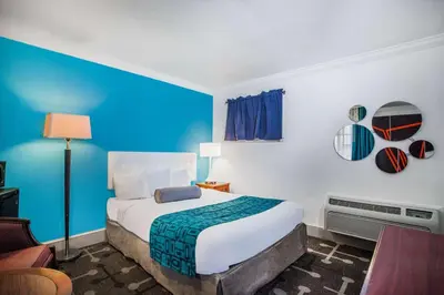 a bedroom with a bed and a blue wall at Howard Johnson by Wyndham Hershey in Hershey