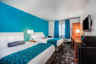 a hotel room with two beds and a flat screen tv at Howard Johnson by Wyndham Hershey in Hershey