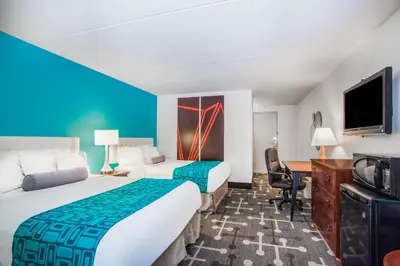 a hotel room with two beds and a desk at Howard Johnson by Wyndham Hershey in Hershey