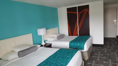 two beds in a hotel room with blue walls at Howard Johnson by Wyndham Hershey in Hershey