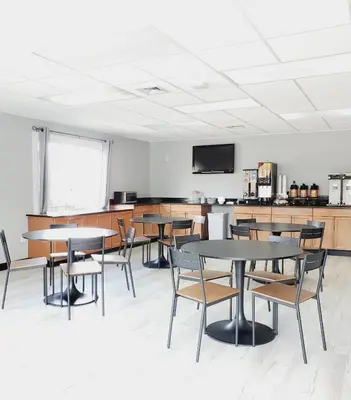a classroom with tables and chairs and a flat screen tv at Howard Johnson by Wyndham Hershey in Hershey