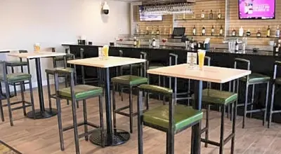 a restaurant with four tables and green chairs at Holiday Inn Scranton East - Dunmore by IHG in Dunmore