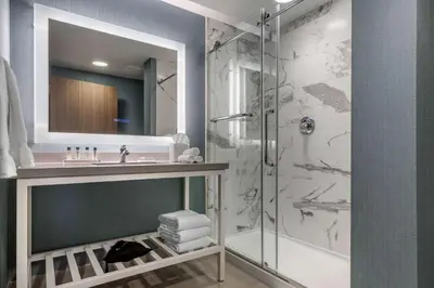 a bathroom with a shower and a sink at Cambria Hotel West Orange in West Orange